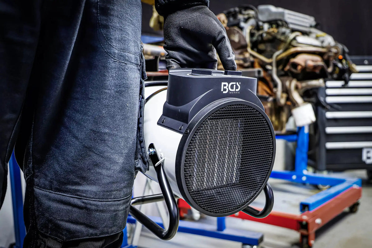 Tragbarer Heizlüfter elektrisch 3 kW für Garage und Haushalt, handlich im Einsatz. Perfekt für flexible Wärmeversorgung in Werkstätten.