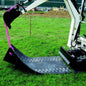 Robuste Bodenschutzmatte für Kettenfahrzeuge und Schwerlastfahrzeuge auf Rasenfläche, ideal für Garten- und Landschaftsbau.