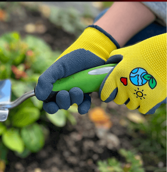 Kinder trägt den Kinderhandschuh Kids 4 Gr. 04 beim Gärtnern. Robuster 15 Gauge Polyester-Handschuh für sicheren Griff und Schutz.